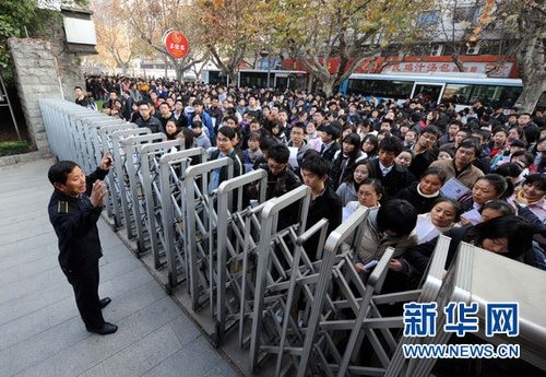     12月5日，在南京女子中专考点，一名工作人员向参加国家公务员考试的考生讲进场注意事项。新华社记者 孙参 摄