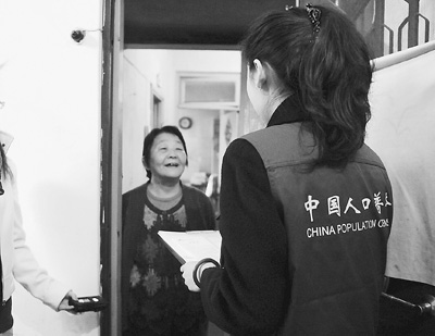 图为11月1日，在北京市呼家楼北里小区内，人口普查员身着工作服，胸戴工作证入户登记。王苡萱摄